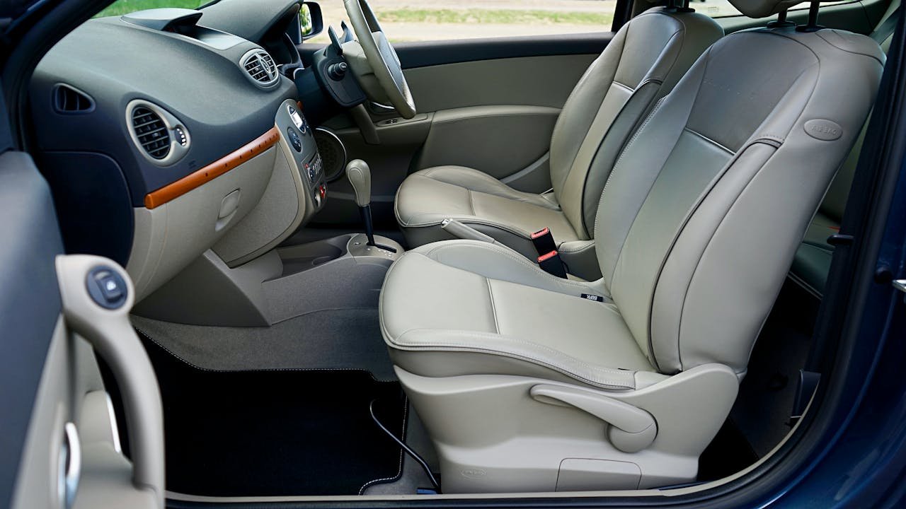 Luxurious car interior with beige leather seats and sleek dashboard.